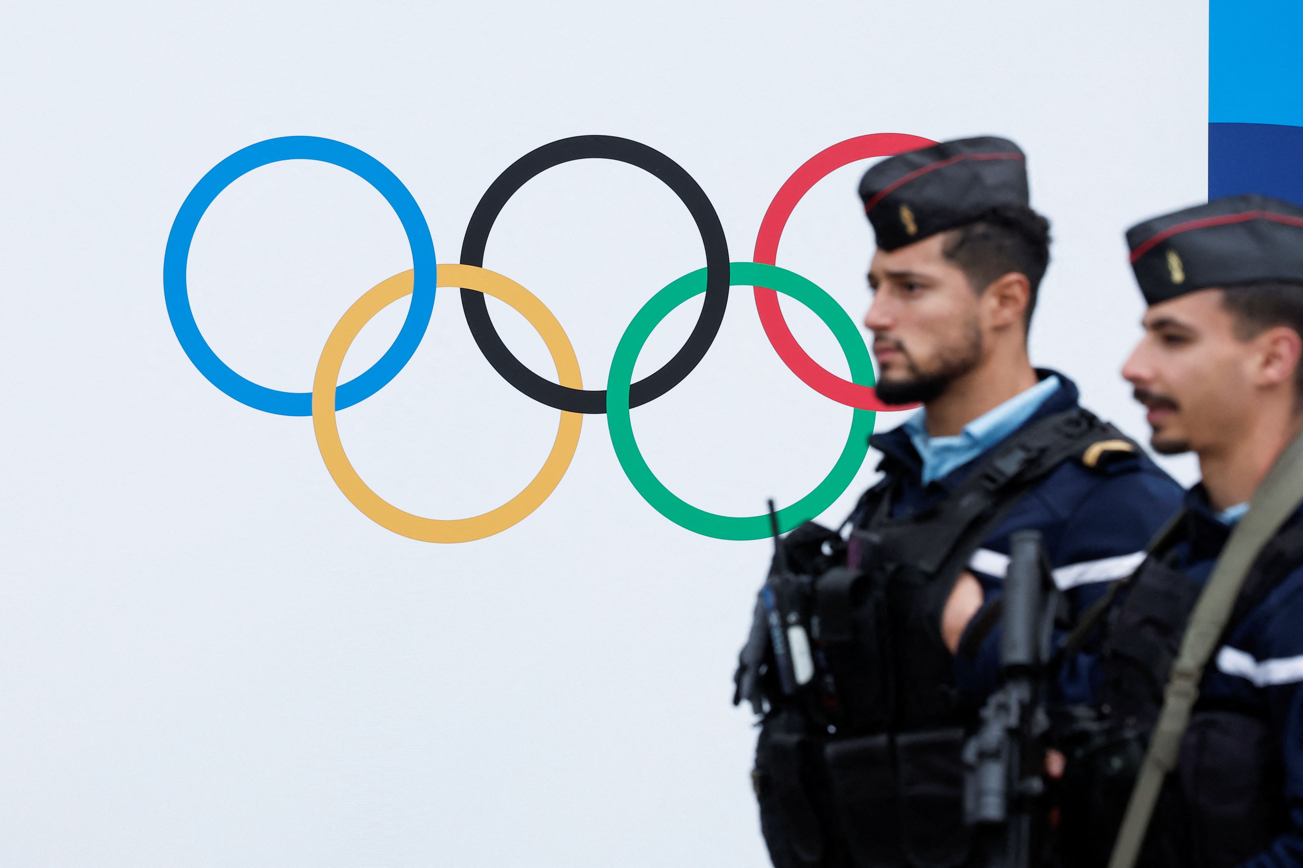 Policiais diante de símbolo dos Jogos Paris 2024