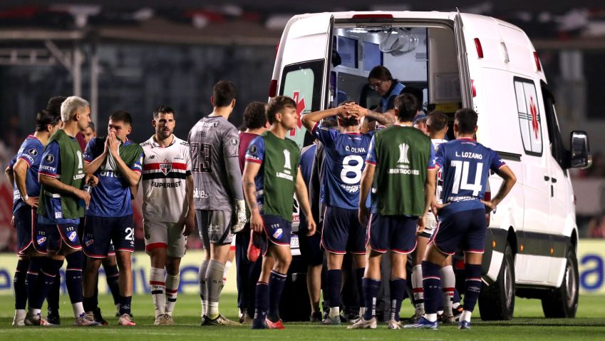 Jogadores de Nacional e São Paulo acompanham atendimento ao zagueiro Juan Izquierdo, do Nacional, após entrada de ambulância no gramado durante partida entre as duas equipes pela Copa Libertadores em São Paulo • 22/08/2024 REUTERS/Carla Carniel