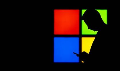 Um homem olha para seu telefone enquanto passa pelo estande