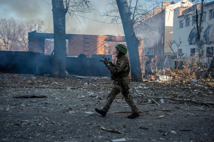Soldado ucraniano caminha em frente a prédio em chamas na cidade de Bakhmut, na linha de frente da guerra / 13/02/2023 Forças Armadas da Ucrânia/Divulgação via REUTERS
