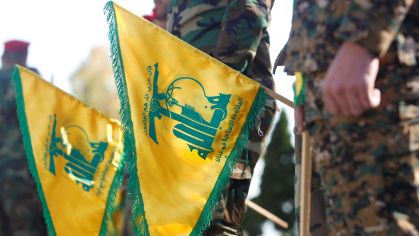 Integrantes do Hezbollah seguram bandeiras com o símbolo do grupo próximos à fronteira de Israel.