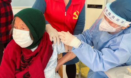 Profissional de saúde aplica vacina contra Covid-19 em idosa nos