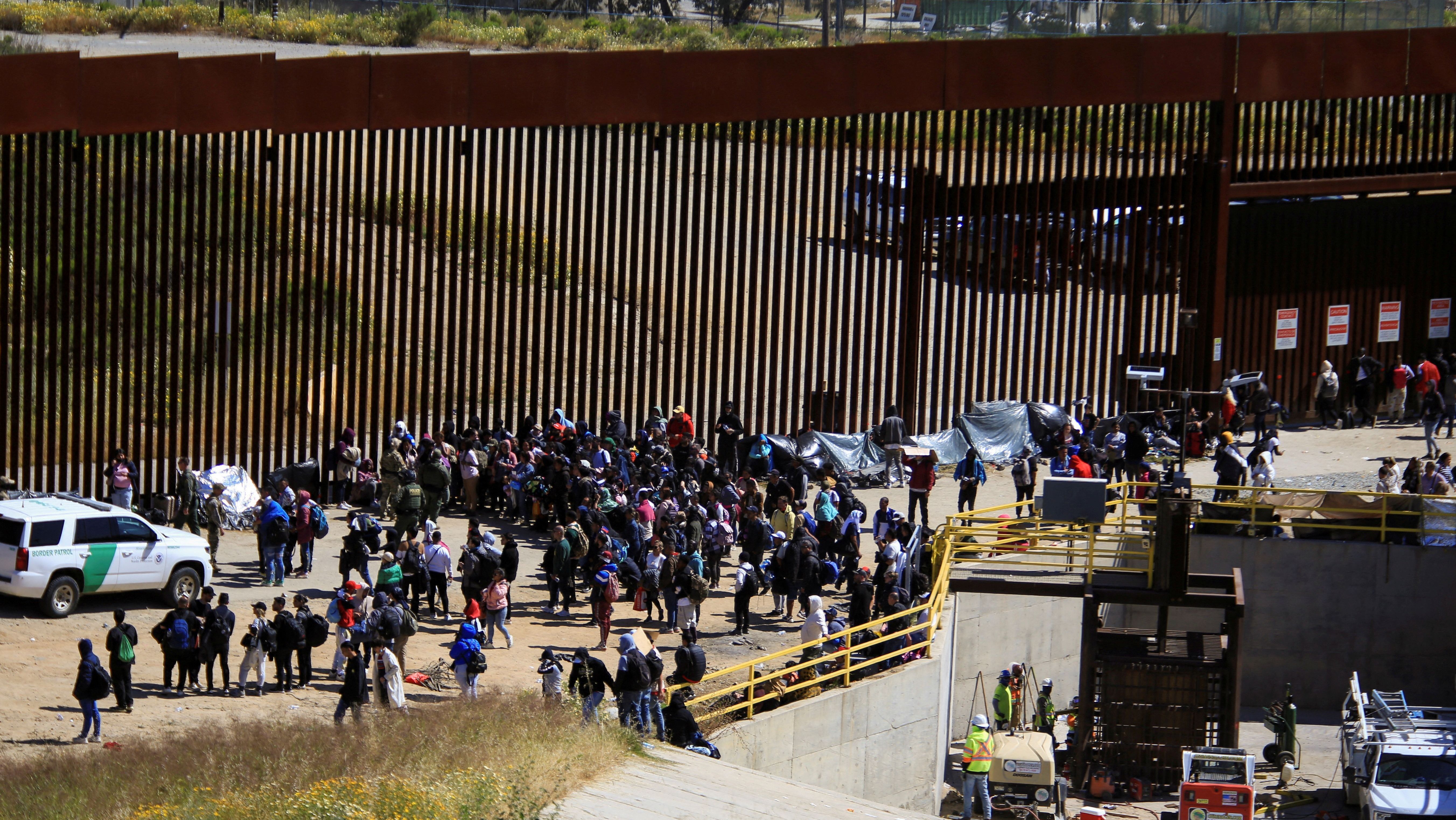 Imigrantes se aglomeram em muro que separa México dos Estados