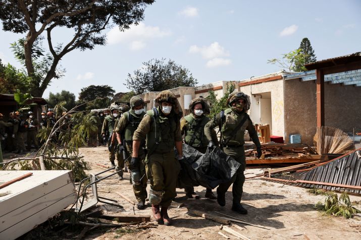 Soldados israelenses carregam corpo de vítima de ataque realizado por militantes de Gaza no kibutz de Kfar Aza, no sul de Israel / 10/10/2023 REUTERS/Violeta Santos Moura