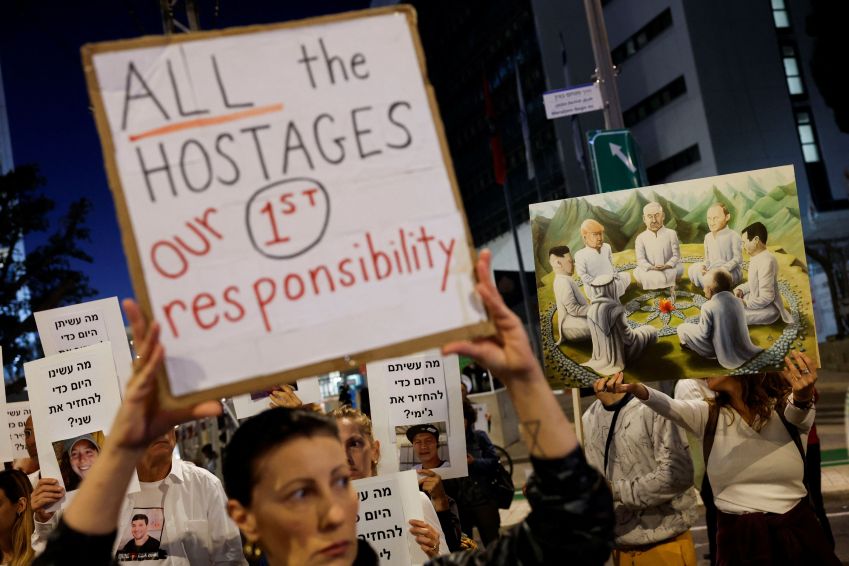 Manifestantes, em Tel Aviv, seguram cartazes exigindo a libertação de reféns detidos na Faixa de Gaza depois de terem sido capturados por homens armados do Hamas em 7 de outubro / 21/11/2023 REUTERS/Amir Cohen