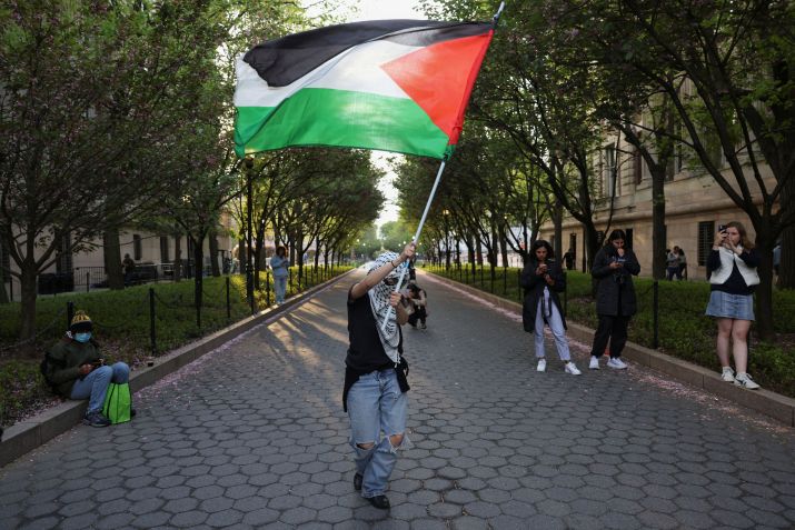 Pessoa segura bandeira palestina do lado de fora da Universidade de Columbia