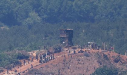Norte-coreanos trabalham em cerca militar perto de posto de guarda
