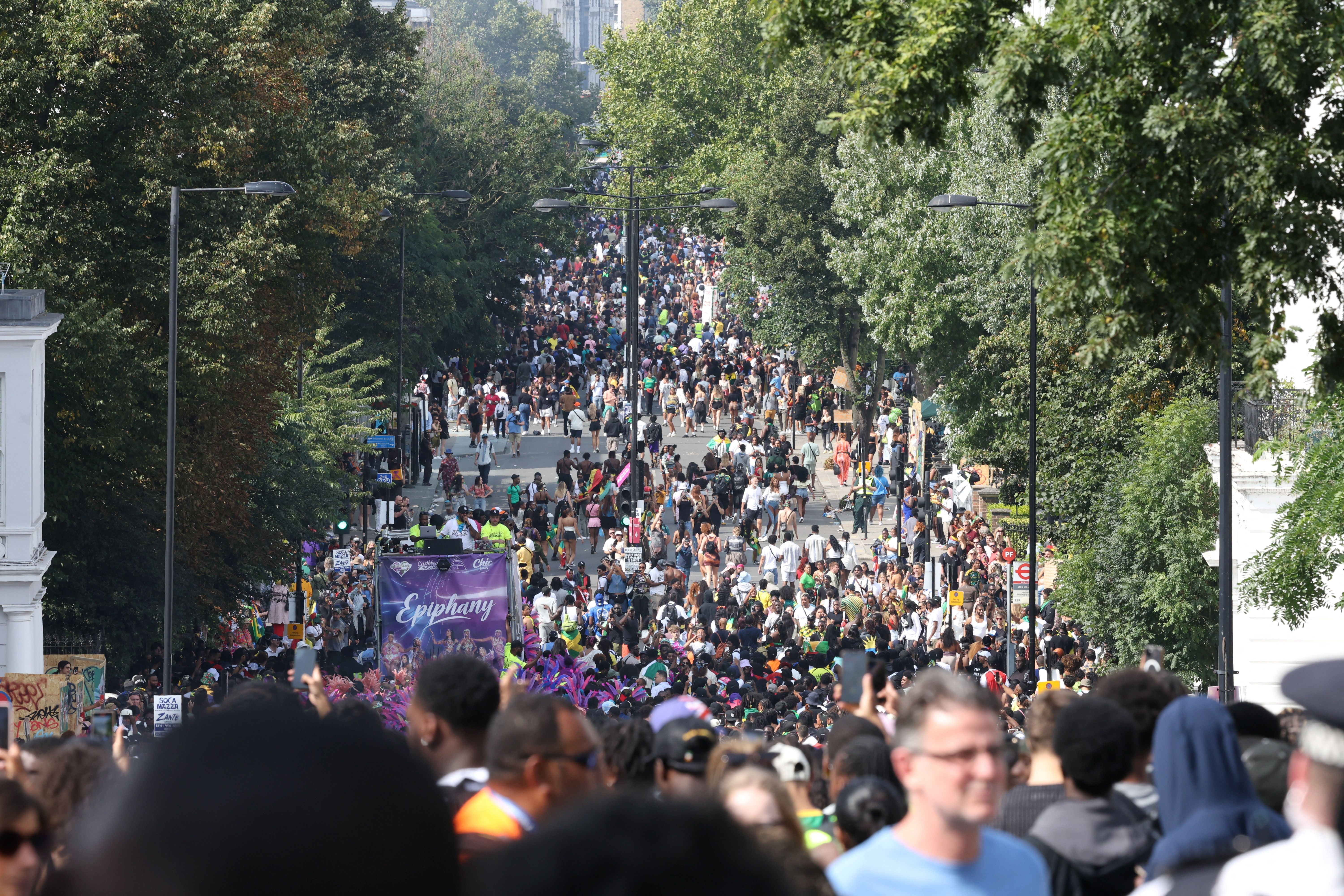 Pessoas caminham na rua Ladbroke Grove durante o Carnaval de