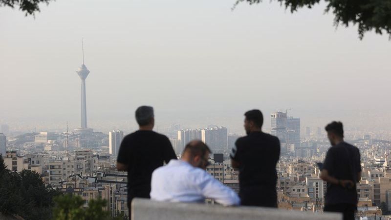 Homens observam a paisagem urbana após os ataques israelenses em